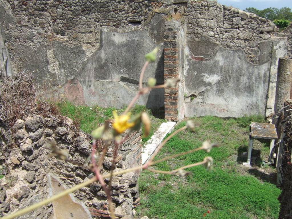 VII.12.28 from VII.12.35, Pompeii. May 2006. Looking east towards the north portico, and white marble threshold of exedra. In the lower left, the upper north-east corner of the plastered wall of a cubiculum can be seen.
