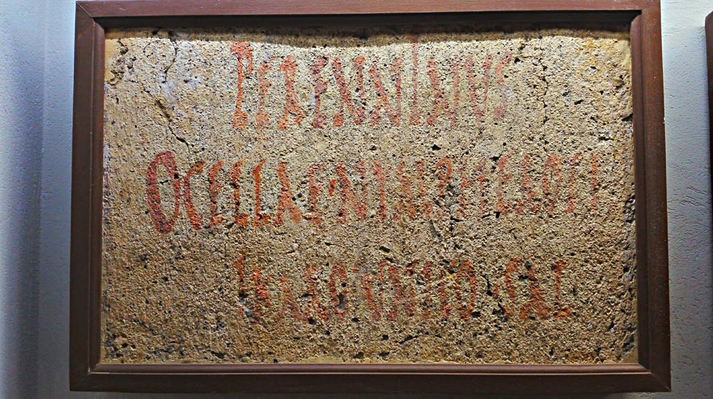 VIII.7.16 Gladiators Barracks, Pompeii. Fragment of painted plaster with red letters, found on the right wall.
Translated as – “Perenninus to Ocella, Ninferotes and Icarus, a special greeting.”
Now in Naples Archaeological Museum, Epigraphic section, inv. 4663.
Photo courtesy of Giuseppe Ciaramella.