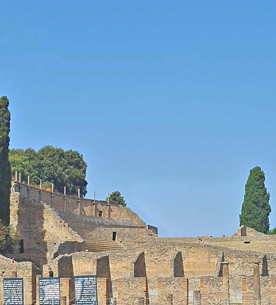 VIII.7.16 Pompeii. September 2024.
Looking north-west to upper level of Large Theatre, from Gladiator’s Barracks. Photo courtesy of Giuseppe Ciaramella.