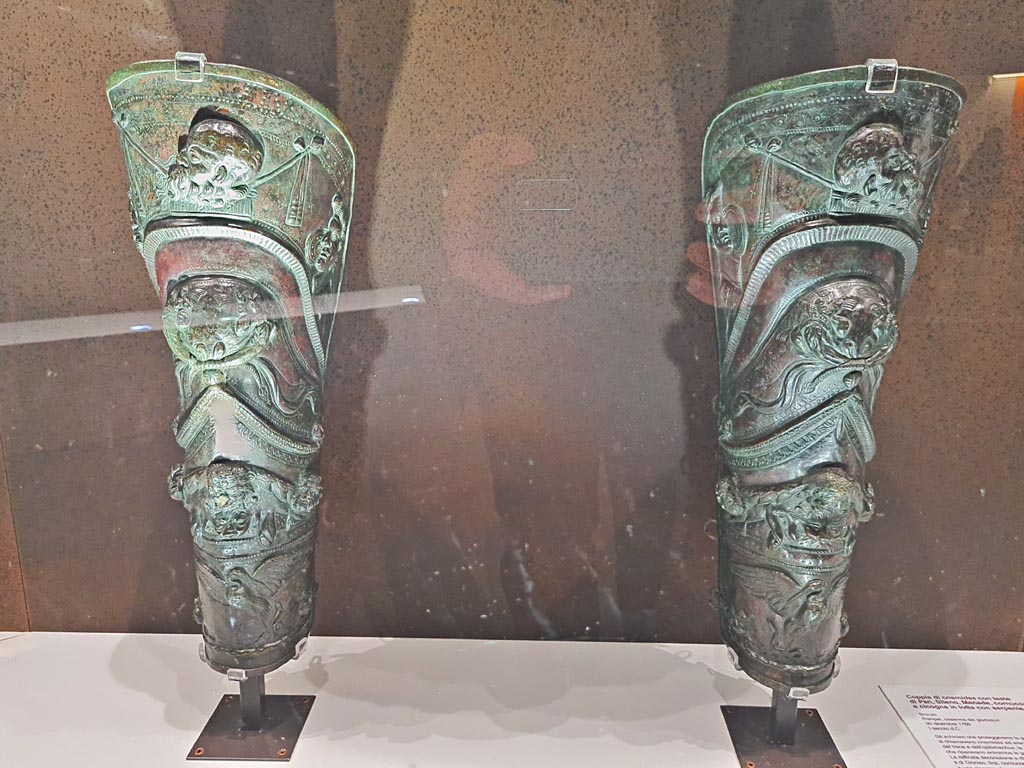 VIII.7.16 Pompeii. Pair of richly decorated greaves each depicting a procession in celebration of Bacchus, Silenus with masks of the god and a lion skin, and a stork fighting a snake.
Photo taken May 2021, courtesy of Giuseppe Ciaramella.