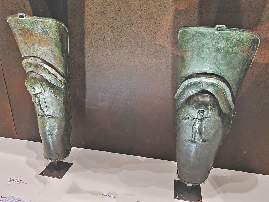 VIII.7.16 Pompeii.
Pair of bronze leggings or Gladiator’s Greaves found in the barracks.
On left - Bronze Greave with depiction of Jupiter, inv. 5645.
On right – Bronze Greave with depiction of Neptune, inv. 5647
Photo taken May 2021, courtesy of Giuseppe Ciaramella.