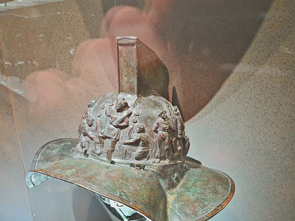 VIII.7.16 Pompeii. Photo taken May 2021, in Naples Archaeological Museum, inv. 5674.
Murmillo gladiator’s helmet, with personification of Rome, Barbarian captives, trophies and Victories.
(Side 1- detail). Photo courtesy of Giuseppe Ciaramella.