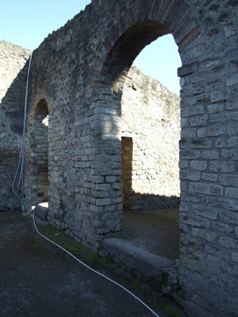 VIII.7.28 Pompeii. March 2009. Doorway to priest’s dining room showing connecting door to kitchen in east wall (in shade).