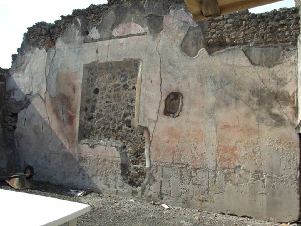 IX.2.16 Pompeii. March 2009. North wall of atrium. According to Bragantini, the floor was made of cocciopesto with a pattern of large white tesserae dots. The dado of the atrium was discoloured or faded. The middle zone of the walls were red, separated into panels by white compartments with candelabra. The frieze was white, and the upper zone would have been red.
See Bragantini, de Vos, Badoni, 1986. Pitture e Pavimenti di Pompei, Parte 3. Rome: ICCD. (p.414, atrio ‘d’)
According to Sogliano, other paintings found on the walls of the atrium apart from Hercules and Hesione, and Bellerophon, were –
Flying cupids (2) (p.59, nos: 324 and 325)
Flying cupid, with a plate in his left hand, and something undistinguishable in his right (p.60, no.331)
See Sogliano, A., 1879. Le pitture murali campane scoverte negli anni 1867-79. Napoli: Giannini. 
