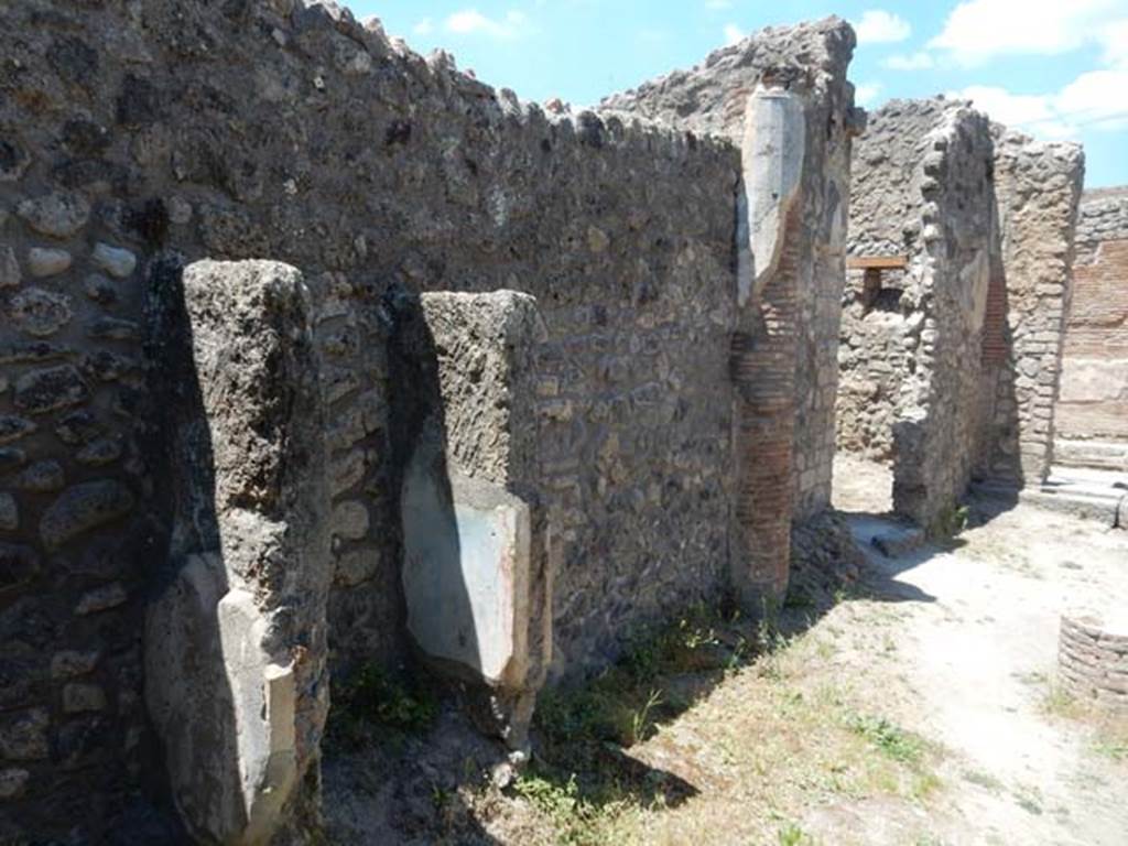 IX.2.27 Pompeii. May 2017. Remains of shrine on wall of peristyle, looking north along west wall towards doorway to kitchen/latrine. Photo courtesy of Buzz Ferebee.