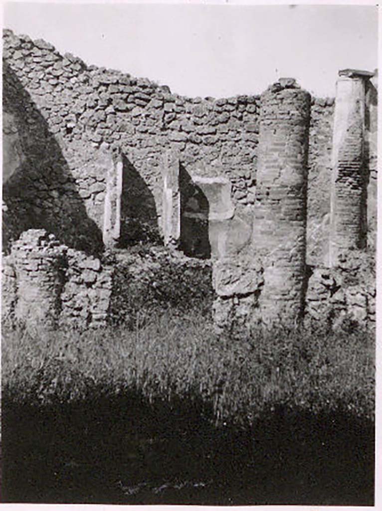 IX.2.27 Pompeii. Pre-1943. Photo by Tatiana Warscher.
According to Warscher – this house may have served as a workshop.
Against the west wall of the peristyle-like room entered directly from the street, stands a shrine;
above a low podium (1.10 x 0.70, height 0.40) two enclosing walls (height as far as preserved 1.30) built against the wall of the room form a rectangular niche (w.0.60, d. 0.50). The floor is not preserved. The inside walls are painted with blue with red borders.
On the ground in front of the shrine stands a square masonry altar.
Giorn. Scavi, N.S, ii, 1870, p.10.
Bull. Inst., 1871, p.177.
See Warscher, T. Codex Topographicus Pompeianus, IX.2. (1943), Swedish Institute, Rome. (no.136.), p. 251.