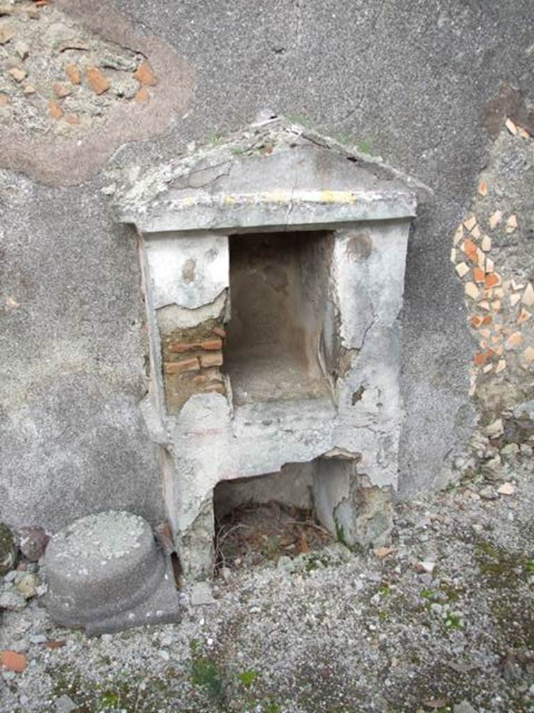 IX.3.15 Pompeii. March 2009. Room 12, aedicula lararium. According to Boyce, the base contained a large rectangular recess, coated with white stucco. Above it the thick side walls and the rear wall of the room formed a rectangular niche. In the back wall of the rectangular niche was a semi-circular recess. The interior was decorated with red spots on a white background. The tympanum was blue. There were red stripes dividing the exterior of the structure into sections.
See Boyce G. K., 1937. Corpus of the Lararia of Pompeii. Rome: MAAR 14. (p. 84, 414, Pl. 34, 1) 
