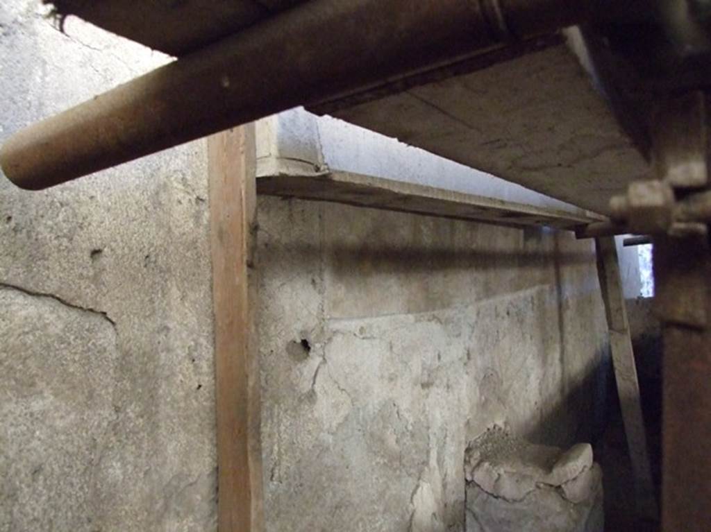 IX.12.6 Pompeii. March 2009. Room “n1”, west wall of internal garden.
Lararium painting behind boarding, with two painted serpents below. Against the wall is the altar.