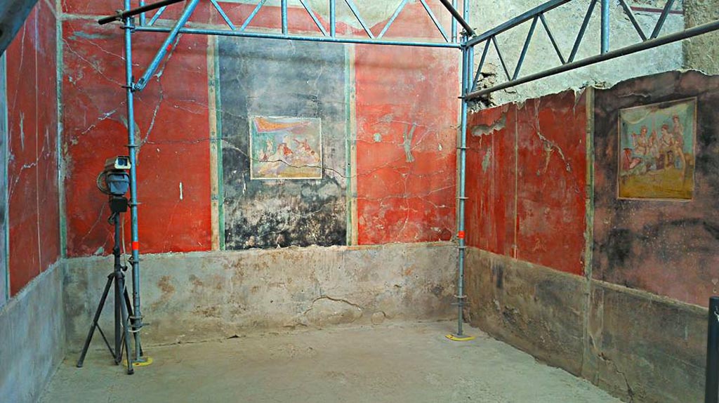 IX.12.6 Pompeii. 2016/2017. Room “m”, triclinium.
Looking towards north wall, north-east corner and east wall both with banqueting scenes. Photo courtesy of Giuseppe Ciaramella.