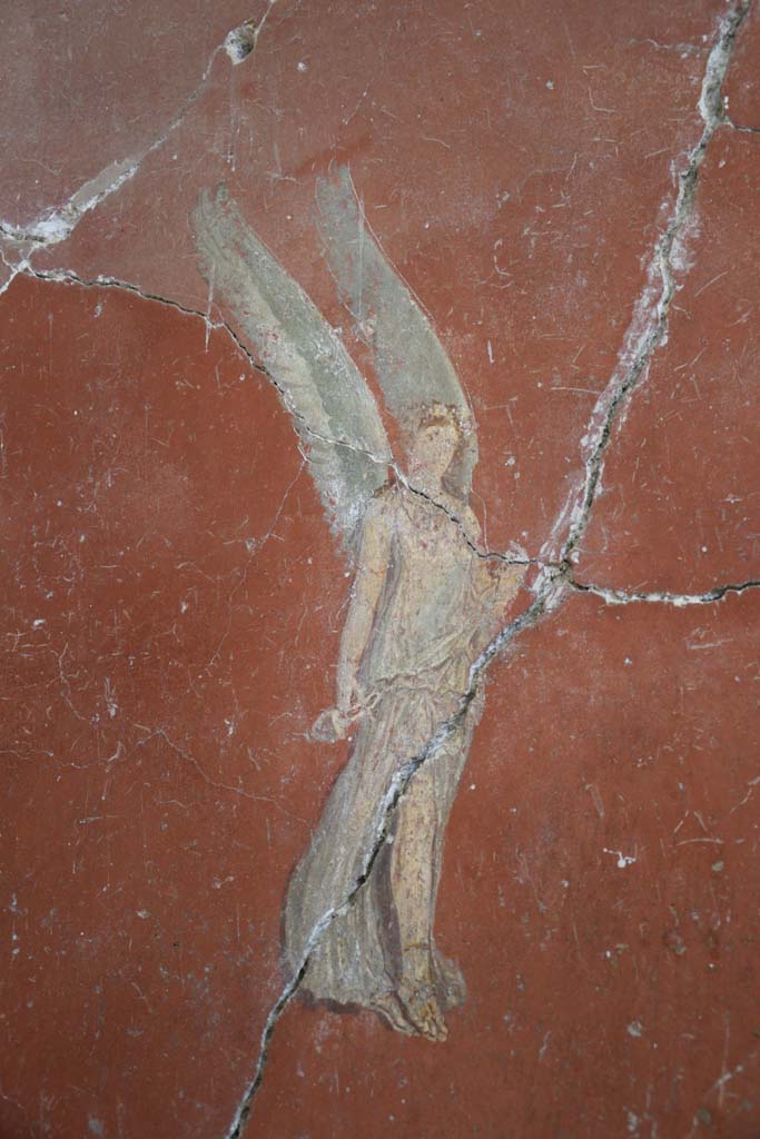 IX.12.6 Pompeii. February 2017.
Room “m”, painting of flying figure on west side of central painting on north wall.
Photo courtesy of Johannes Eber.