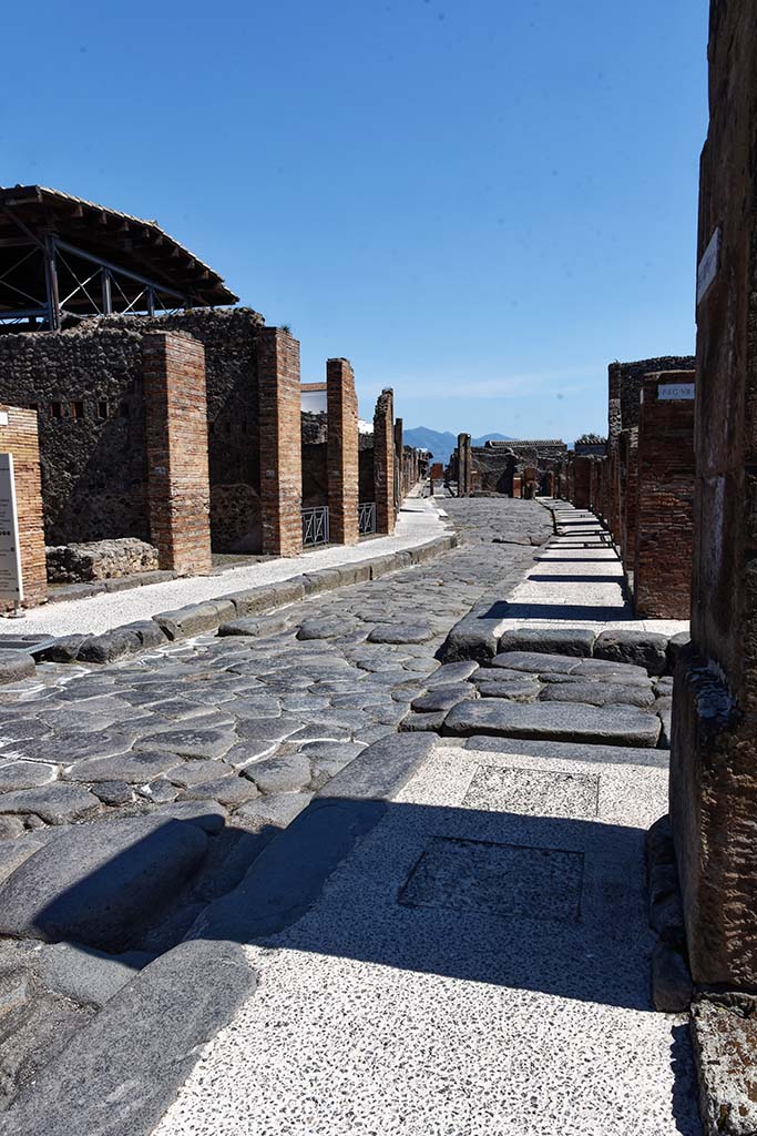 Via dell’Abbondanza, April 2021. 
Looking east between VII.1 and VIII.4 from junction of Via degli Teatri, on right. 
The section between VIII.4 and VII.1 was previously known as the Strada d’Olconio under Spinelli’s enumeration.
Photo courtesy of Nicolas Monteix.  

