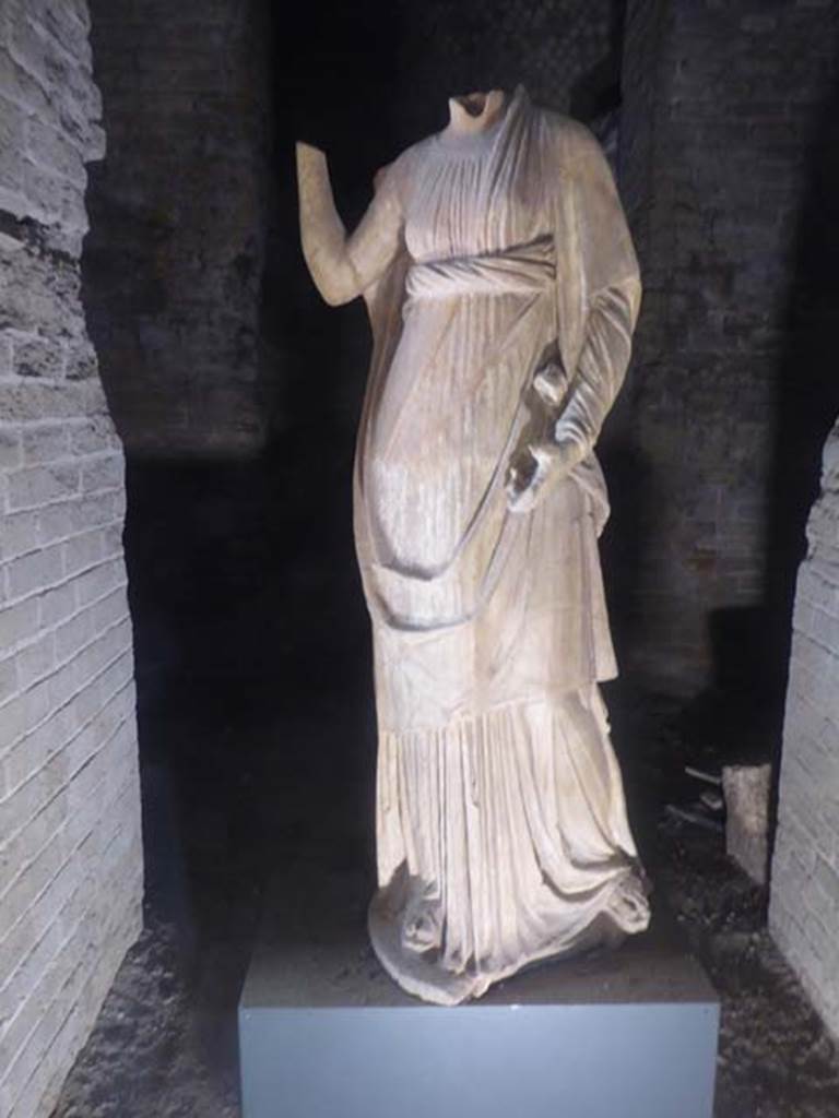 Santuario extraurbano del Fondo Iozzino. June 2017. Female statue possibly of Ceres/Demeter, dating to the mid to late 2nd century BC.
Photo courtesy of Michael Binns.
According to D’Ambrosio and Borriello, the statue was headless, fractured at about half of the neck.
The back is recomposed from fragments; the right forearm is reattached.
The right hand is missing; the fingers of the left, the toes and the base plate are missing.
There are slight gaps and large abrasions on the rear of the statue and chipping in the drapery.
Now in SAP deposits. Inventory number 13151.
See D’Ambrosio A., Borriello M. 1990. Le Terrecotte Figurate Di Pompei. Roma: L’Erma di Bretschneider, 20, p. 26, tav. 6.