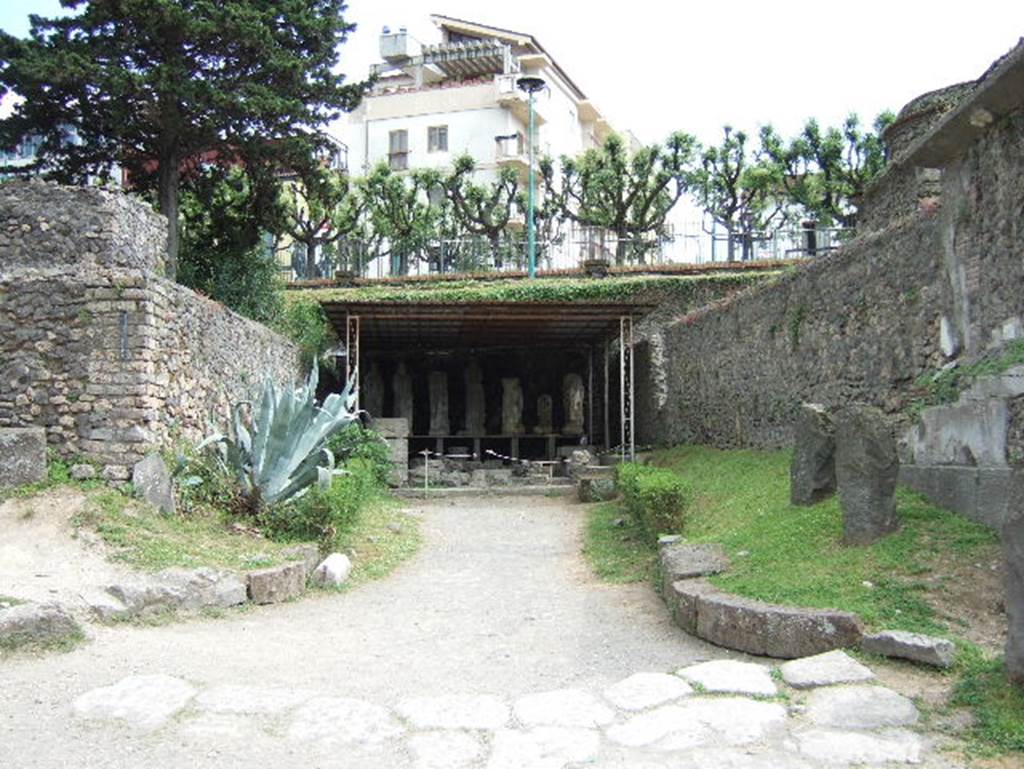 Pompeii Porta Nocera. May 2006. Display area for items found in or near the tombs, on south side of Via delle Tombe.
On the left is tomb 1ES and on the right with two upright stones next to it is tomb 1OS, behind it is tomb 3OS.