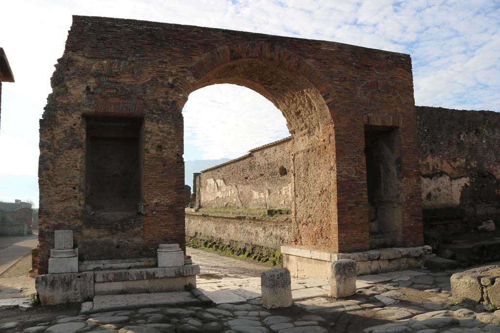 Arch at north-east end of the Forum. December 2018. 
Looking south-west from Via del Foro, into the Forum. Photo courtesy of Aude Durand.
