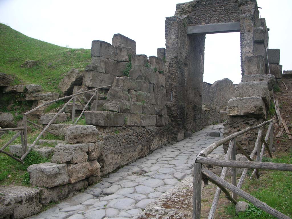 Porta di Nocera or Nuceria Gate, Pompeii. May 2010.Looking towards west side of gate. Photo courtesy of Ivo van der Graaff.
According to Van der Graaff –
“The current structure repeats the familiar layout: outer travertine bastions, a tuff gate court, and a concrete vault.
In the traditional view, each element should represent a separate construction event. The remains tell a different story.
The foundations of the gate are visible because engineers lowered the road passing through it after the establishment of the Roman colony (Note 67). 
Proof of this arrangement comes from simple observation.
The sidewalk leading up to the gate, as well as the struts that once supported the gate leaves, are unduly high in comparison to the road.
The lowest four courses of the masonry composing the gate court display quarry marks and are laid down as ashlars. 
By contrast, the upper courses stand vertically as orthostats and are dressed to a smooth surface.
All of the masonry of the gate court stands on a thick opus incertum foundation.
This concrete base displays a seamless tradition with the masonry of the vault behind it. (See Plate 11, as above photo).”
See Van der Graaff, I. (2018). The Fortifications of Pompeii and Ancient Italy. Routledge, (p.60).
On page 62, he continues –
“Nevertheless, given the massive expansion of the agger, the current layout of the Porta Nocera must be contemporaneous with the upgrade of the adjacent fortifications that occurred in the second century BCE (Note 70). This date makes the Porta Nocera a laboratory of sorts for the application of opus incertum as a new construction technique.” 
