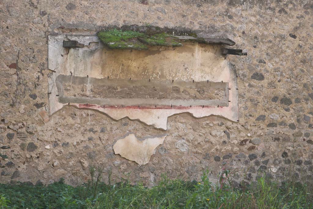 VII.10.14 Pompeii. December 2018. Painted decoration on south wall. Photo courtesy of Aude Durand.
According to Jashemski, this was a badly preserved painting with plants and birds that were still faintly visible in l993.
See Jashemski, W. F., 1993. The Gardens of Pompeii, Volume II: Appendices. New York: Caratzas. (p. 191)
Boyce reported there was a garden painting on the north (?) wall, and in front of it was a masonry altar with a step on the front of it.
Boyce said the wall was painted with trees, plants and birds. 
The altar (0.60 by 0.36, h.0.80) was coated with white stucco and decorated with the following painted objects.
On the front side, a shallow dish with fruits and a pine cone. 
On the left side, two trees with an altar between them, with the attributes of Diana around it, a crown, a bow, a quiver, two hunting spears, two dogs and a torch. 
On the right side, a rural shrine scene consisting of a column and capital, and on the top of the capital a basket containing two rhyta, a jar, a phallus-like object covered with a red cloth; across the field was painted a thyrsus.
See Boyce G. K., 1937. Corpus of the Lararia of Pompeii. Rome: MAAR 14. (p. 69, no.307). 
According to Amoroso, this is the lararium painting [on the south wall].
See Studi della Soprintendenza archeologica di Pompei, 22: l'Insula VII, 10 di Pompei, by Angelo Amoroso. ((p.111, fig. 40a).
According to PPM, the lararium painting was on the south wall of the viridarium (s).
See Carratelli, G. P., 1990-2003. Pompei: Pitture e Mosaici. VII. Roma: Istituto della enciclopedia italiana, (p.416, no. 64).

