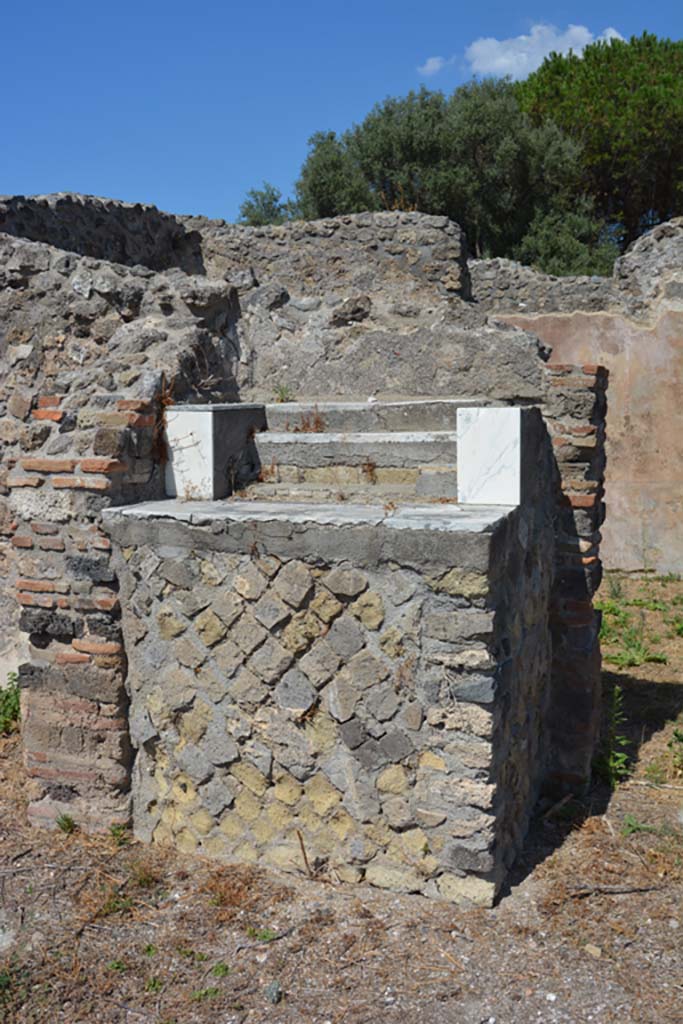 VIII.2.28 Pompeii. March 2019. Lararium base in north-west corner of atrium.
Foto Annette Haug, ERC Grant 681269 DÉCOR.
According to Boyce -
In the north-west corner of the atrium is a masonry base (1.25 by 0.85, h.1.16), later in date than the stucco of the walls of the room. 
It is coated with stucco and painted in imitation of coloured marble and upon the top stand three small steps of fine greyish marble.
The aedicula that was originally on the base has disappeared. 
Above on the north wall, at the time of excavation, there were still traces of the figures of the Lares, which alone remained from the lararium painting. 
See Boyce G. K., 1937. Corpus of the Lararia of Pompeii. Rome: MAAR 14. (p74, no.345)
See Giacobello, F., 2008. Larari Pompeiani: Iconografia e culto dei Lari in ambito domestico. Milano: LED Edizioni, (p.246, no.A31)
According to NdS – 
“The base was faced with plaster imitating coloured marble, on top of which were three small steps recovered with precious coloured marble.”
See Notizie degli Scavi di Antichità, 1887, (p.511).



