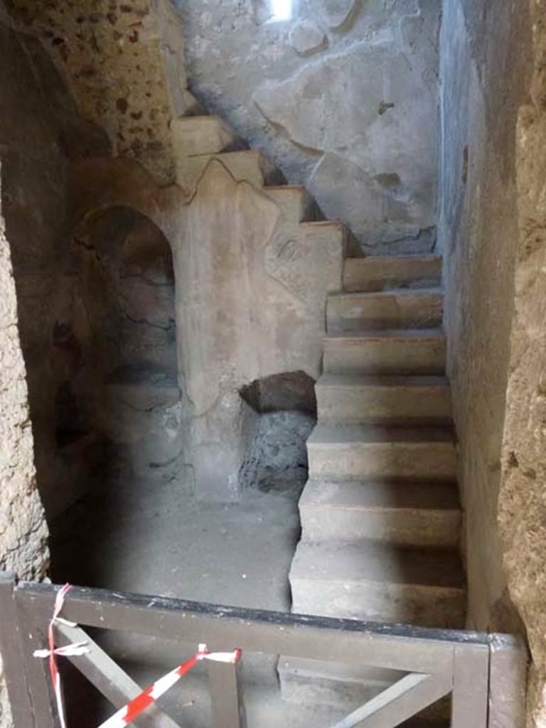 I.10.4 Pompeii. June 2012. 
Room 2, small room on east side of aedicula lararium in atrium, with niche and recess below stairs to upper floor. 
According to Boyce, in a small room with an arched recess beneath the stairs, 
there was a small masonry altar with two cavities in the top, and a niche in the wall above.
See Boyce G. K., 1937. Corpus of the Lararia of Pompeii. Rome: MAAR 14. (p.28, no.50C).
He quoted his reference as MAIURI, Casa del Menandro, 37.
Photo courtesy of Michael Binns.

