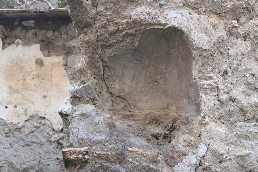 I.10.6 Pompeii. December 2018. Niche on west wall. Photo courtesy of Aude Durand. 
According to Boyce, this arched niche (h.0.33, w.0.43, d.0.23, h. above floor 1.45) was painted red on the inside.
A thick ledge was indicated in the stucco below it, although the floor does not project.
See Notizie degli Scavi di Antichità, 1934, 276f.
See Boyce G. K., 1937. Corpus of the Lararia of Pompeii. Rome: MAAR 14. (p.29, no.55).
