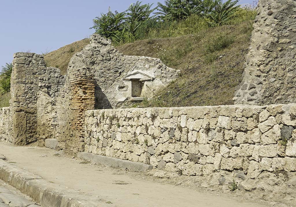 III.7.5 Pompeii. August 2021. 
Wide threshold of doorway in centre, under new wall, on north side of Via dell'Abbondanza. 
A niche with a pediment can now be seen, set into the west wall. 
The narrow threshold of III.7.4 is on the left. Photo courtesy of Robert Hanson.

