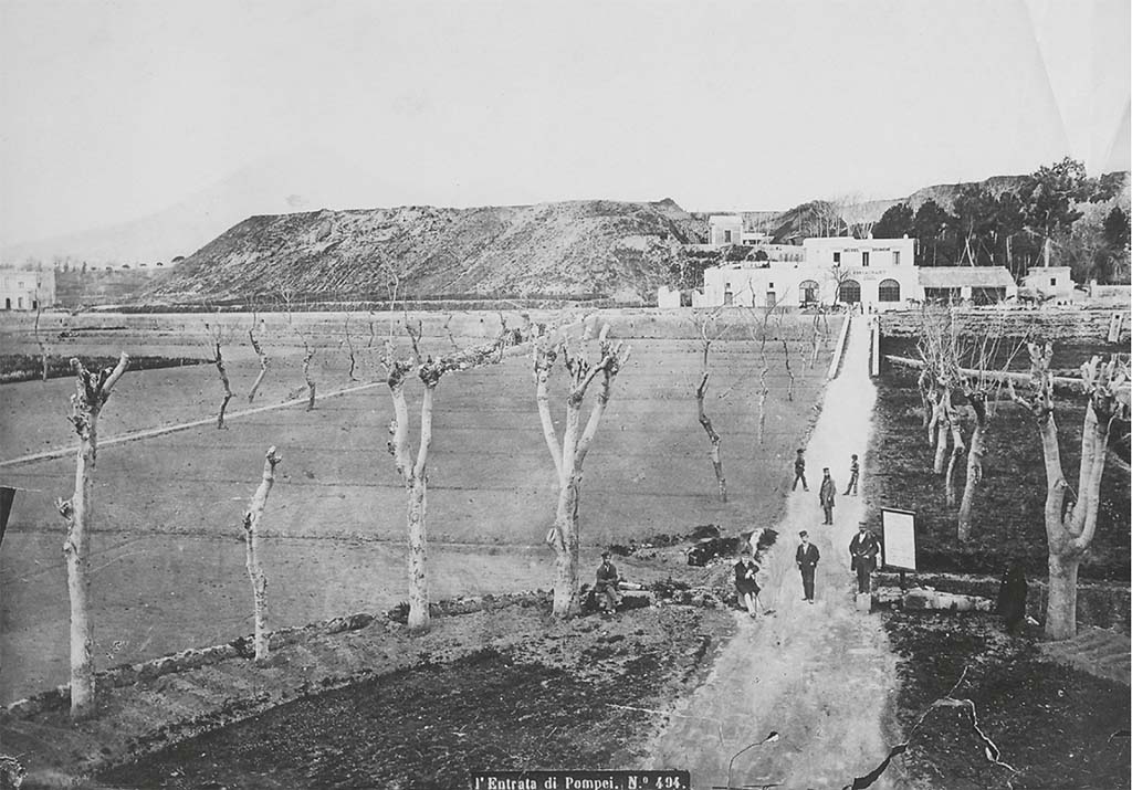 Pre 1889 photo by Roberto Rive (or Giorgio Sommer?), L' Entrata di Pompei, no. 494.
According to Zanella, this shows the entrance to the Pompeii site from the station. Opposite, the Diomede Hotel, taverna del Lapillo. 
On the left, the piles of rubble accumulated since the beginning of the excavation outside the urban perimeter on land that belonged to the Irace family and R. Minervini.
Comparing a drawing by Callet (fig. 27)  dated 1822 and a photograph by the Alinari brothers dated the hotel seems to retain the old configuration of the taverna del Lapillo. In particular, the three front arcades visible the Callet drawing have been preserved from the old tavern. On the other hand, transformations seem to have taken place on the western part of the building where, instead of the open space that can be seen on the older plans, three doors have been pierced in the blind wall visible in the drawing, confirming the widening of the structure shown in later plans. To the east, already at the time of Callet, a barn leans against the factory building. Another building, visible in the photograph of the Alinari brothers, was added later.
See Zanella S., 2019. La caccia fu buona: Pour une histoire des fouilles à Pompéi de Titus à l’Europe. Naples : Centre Jean Bérard, p. 60, fig. 27 and 28.

