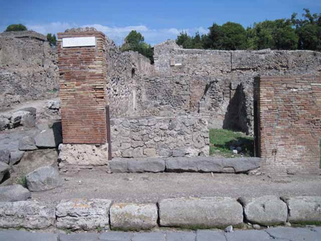 I.1.9 Pompeii. September 2010. Entrance doorway, looking east from Via Stabiana.
Photo courtesy of Drew Baker.

According to Warscher, quoting Mau in Bull.Inst 1875, p.30, I.1.6-9: “Segue un altro albergo, molto simile a questo descritto.  Qui pure è interrotto il marciapiede per lasciar entrare i legni. L’entrata era chiuse mediante una porta a quattro partiti, congiunti a due adue, come si conosce dai quattro buchi per i chiavistelli. Qui pure si entra prima in un compreso che ha le dimensioni d’una bottega grande con una dietrobottega e posteriormente si apre sopra una grande corte, lungo il cui muro di fondo qui pure si stende la stalla, larga 13,30, profonda 2,47 con una finestra sul vico settentrionale e due porte, una all’estremità meridionale, l’altra poco distante da quella settentrionale. 
Presso a quest’ultima una parte della corte è selciata.  Lungo il muro N vi sono due camere con finestre sul medesimo vico, e prossimo alla stalla il cesso. Si vede anche il cesso del piano superiore e i tubi di mattone d’un terzo, che stava ancora più in alto.  
Nell’angolo NO vi sono I primi gradini d’una scala, la cui parte superiore sarà stata di legno, in quello SO l’apertura della cisterna, e accanto nella stessa massa di materiale una vasca lunga stretta e bassa, come quella sudescritta nella casa adiacente. Qui la vediamo frapposto fra la cisterna ed il muro di O, il che esclude categoricamente l’aver essa servito d’abbeveratoio. Dalla parte più bassa di essa, aperta come nella casa sudescritta, l’acqua colava in un’altra vasca larga 1,02 x 1,54, di cui un lato viene formato dalla suddetta massa di fabbrica, uno dal muro occidentale, i due rimanenti da appositi muricciuoli.  Essa ha al fondo uno scolo verso N, che dà in un vaso ossia tubo di mattone, incastrato nel suolo.Nella parete vi era la pittura dei Lari, di cui sono rimasti soltanto i serpi.A destra dell’ingresso per i legni sta un locale come una bottega. 
L’essere esso congiunto mediante una porta con quel primo compreso, ove entravano i legni, ci lascia supporre, aver esso servito di caupona per i vetturini”.
See Warscher T., 1935. Codex Topographicus Pompeianus: Regio I.1/I.5. Rome: DAIR. (no.14)
(for a translation see, I.1.6).
