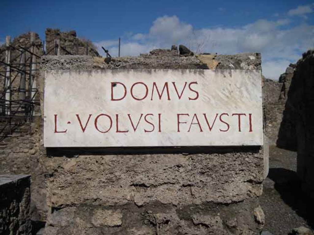 I.2.10 Pompeii. September 2010. Name plate on north side of entrance doorway. The name of this house was derived from a bronze seal found in the house. Photo courtesy of Drew Baker.
According to Warscher, quoting Bull.Inst.1874, p.196, it described – Il nome di Domus L. Volusi Fausti dato a questa casa fu ricavato dal suggello di bronzo in essa rinvenuta e dall’epigrafe sopra anfora (vedi Gli scavi in Pompei nel volume “Pompei e la regione sotterrata, 1879”, p. 11).
See Warscher T., 1935. Codex Topographicus Pompeianus: Regio I.2. (after no.21 and 21a), Rome: DAIR, whose copyright it remains. 

