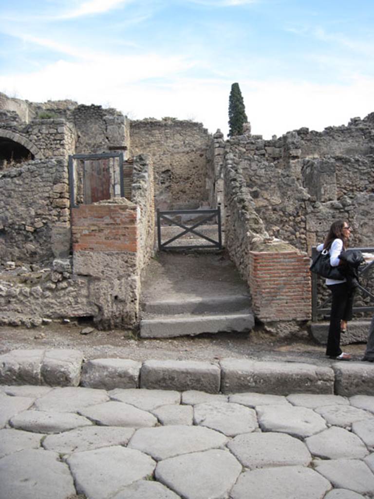 I.3.3 Pompeii. September 2010.  Looking east towards entrance doorway from across Via Stabiana.  Photo courtesy of Drew Baker.
According to Della Corte, this house was spacious and beautifully decorated, with temple-lararium in the atrium and peristyle on a higher level than the atrium.
Della Corte believed the house was owned by Epidius Fortunatus, because an amphora was found here, still containing honey in it, addressed to -
Mel P() P() CXXXIII
dat XXXXXIX s(emissem)
Epidio Fortunato
/
T() P() XXVIII
[…]ens              CIL IV 5740
See Della Corte, M., 1965.  Case ed Abitanti di Pompei. Napoli: Fausto Fiorentino. (p.264)

