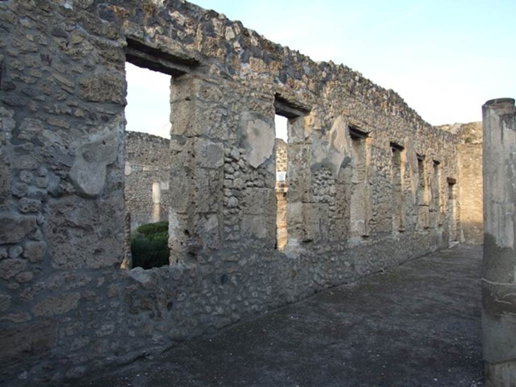 I.4.25 Pompeii. December 2007. 
Looking north-east along the north wall of the lower peristyle 32, with windows to the middle peristyle 17.
Photographed from outside room 36.
