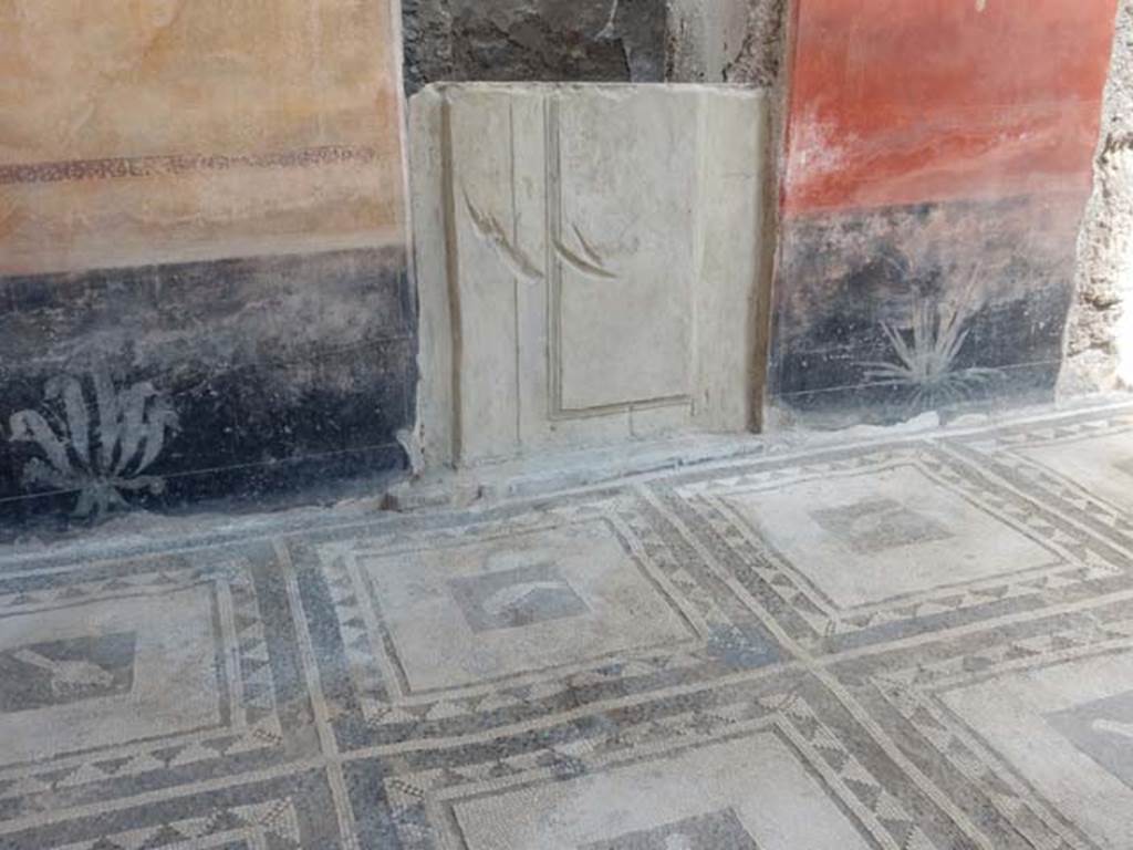 I.7.1 Pompeii. May 2016. Detail of painted plants on black zoccolo of east wall, including cast of doorway. Photo courtesy of Buzz Ferebee.