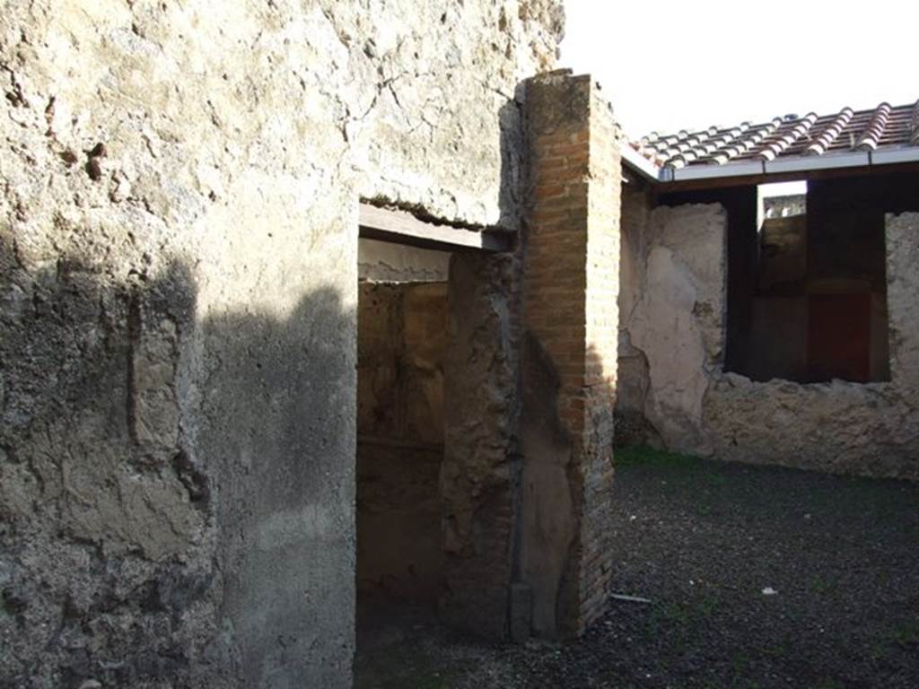 I.7.5 Pompeii. December 2007. East side of vestibule with doorway to cubiculum.  On either side of the vestibule was a pilaster that served as supports for the floor joists of the upper floor. The courtyard and closed tablinum can be seen on the right. On the east side of the courtyard was the kitchen bench, and on the south side were the steps in blocks of Sarno stone.
