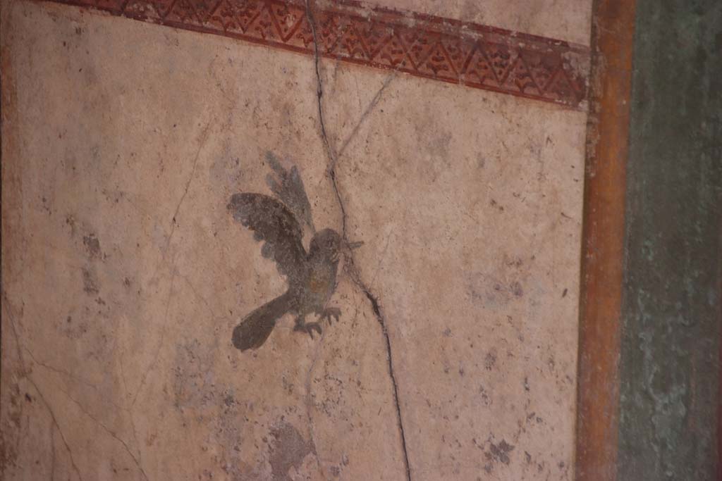 I.7.11 Pompeii. September 2021. South wall of exedra at east end, detail of painted bird in lower panel. Photo courtesy of Klaus Heese.