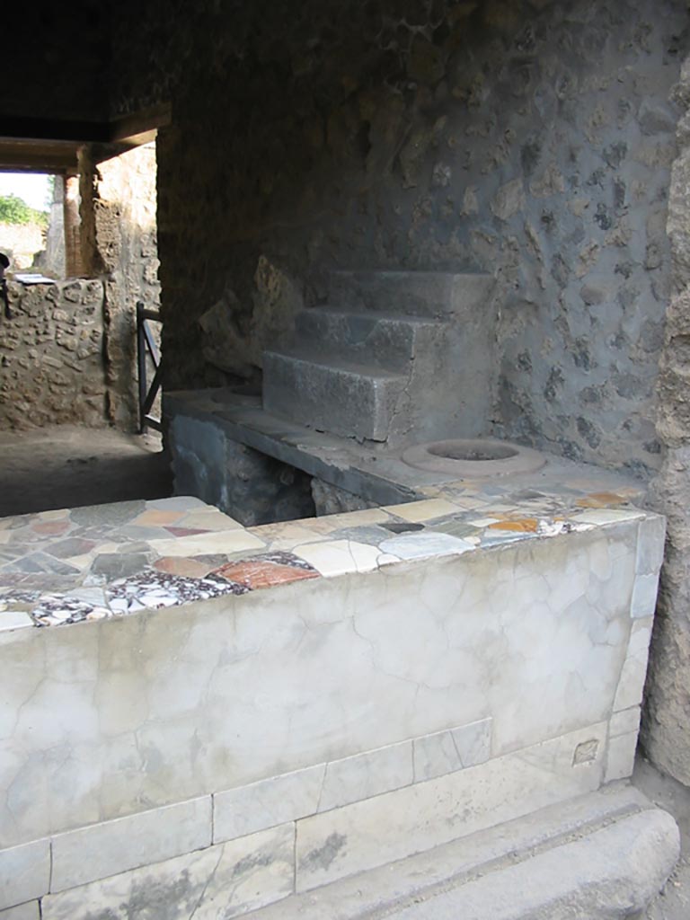 I.9.3 Pompeii. May 2003. 
Counter, display shelving and entrance sill at west end. Photo courtesy of Nicolas Monteix.
