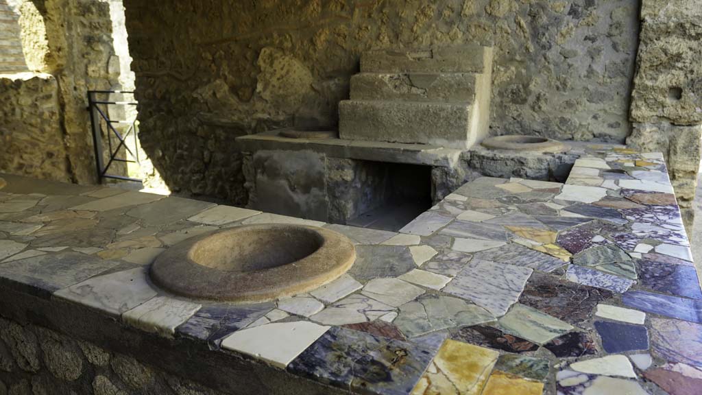 I.9.4 Pompeii. August 2021. Looking towards west wall with display shelving and two urns. Photo courtesy of Robert Hanson.

