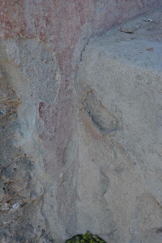 I.10.18 Pompeii. April 2017. 
Detail of remaining painted plaster on south side of bench seating on south side of entrance doorway. 
Photo courtesy Adrian Hielscher.
