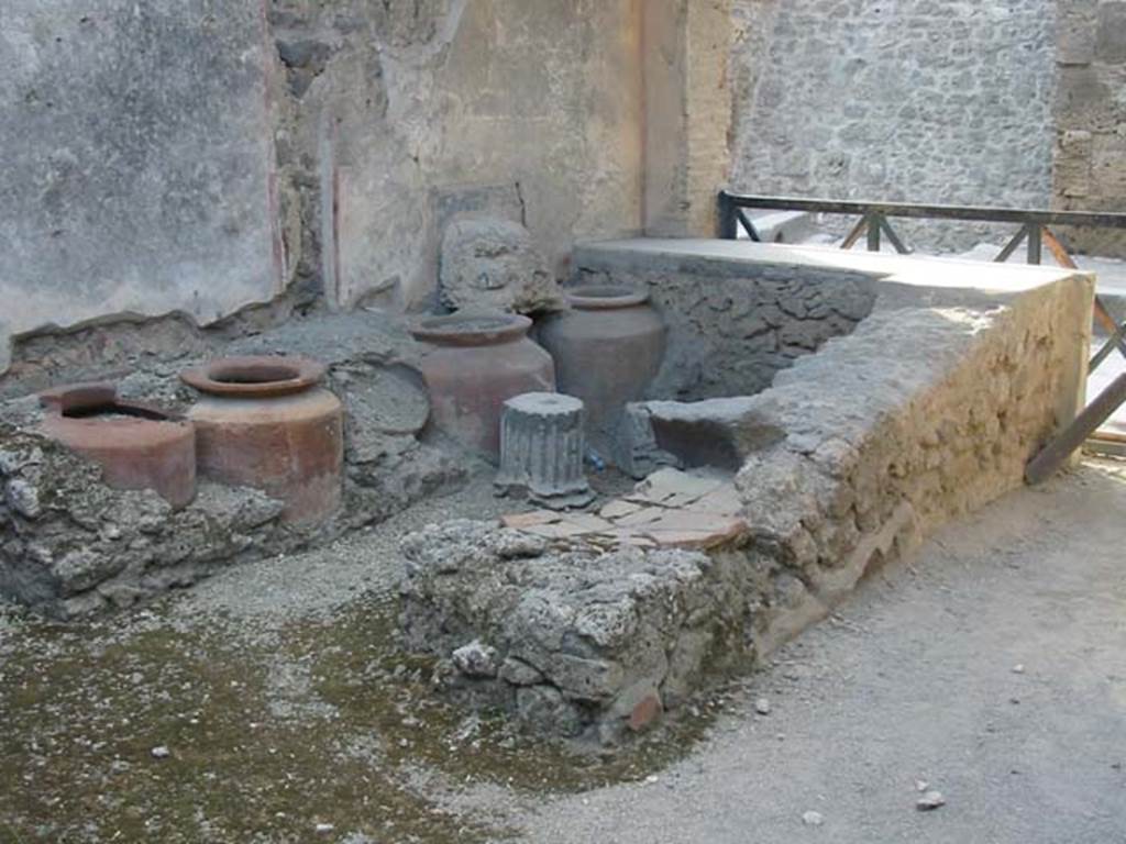 I.11.1 Pompeii. May 2003. Looking towards west wall with four urns, and remains of shelving. Photo courtesy of Nicolas Monteix
