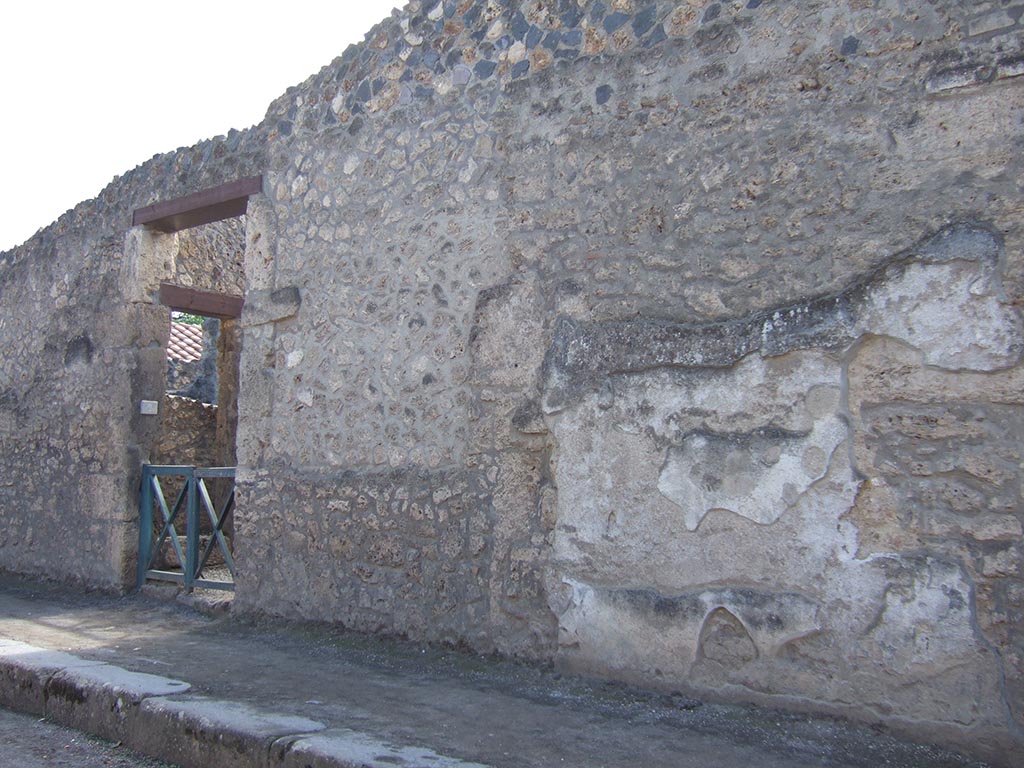 I.13.2 Pompeii. September 2005. Exterior street wall on Via dell’Abbondanza, with blocked doorway to workshop. 