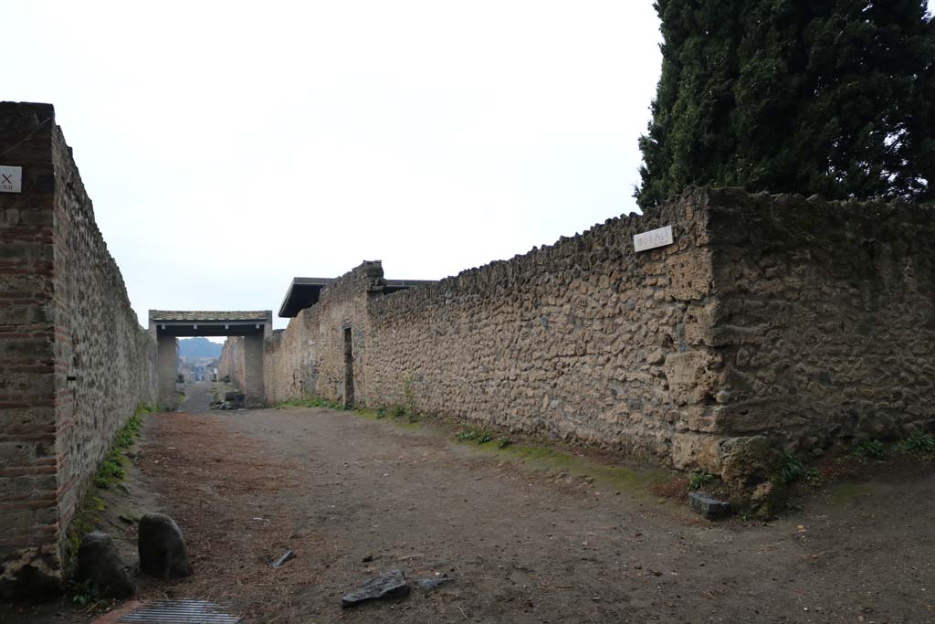 II.1.8 Pompeii. December 2018. 
Looking west along Via di Castricio, with entrance doorway on left of centre, in south wall of garden area of II.1.9. 
On the right is the junction with Vicolo di Octavius Quartio. Photo courtesy of Aude Durand.

