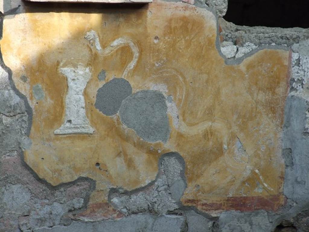 II.1.9 Pompeii. December 2007. Lararium with stucco serpent and altar.
Painting below the niche of a garden (now faded) with a stucco altar and stucco crested serpent.


