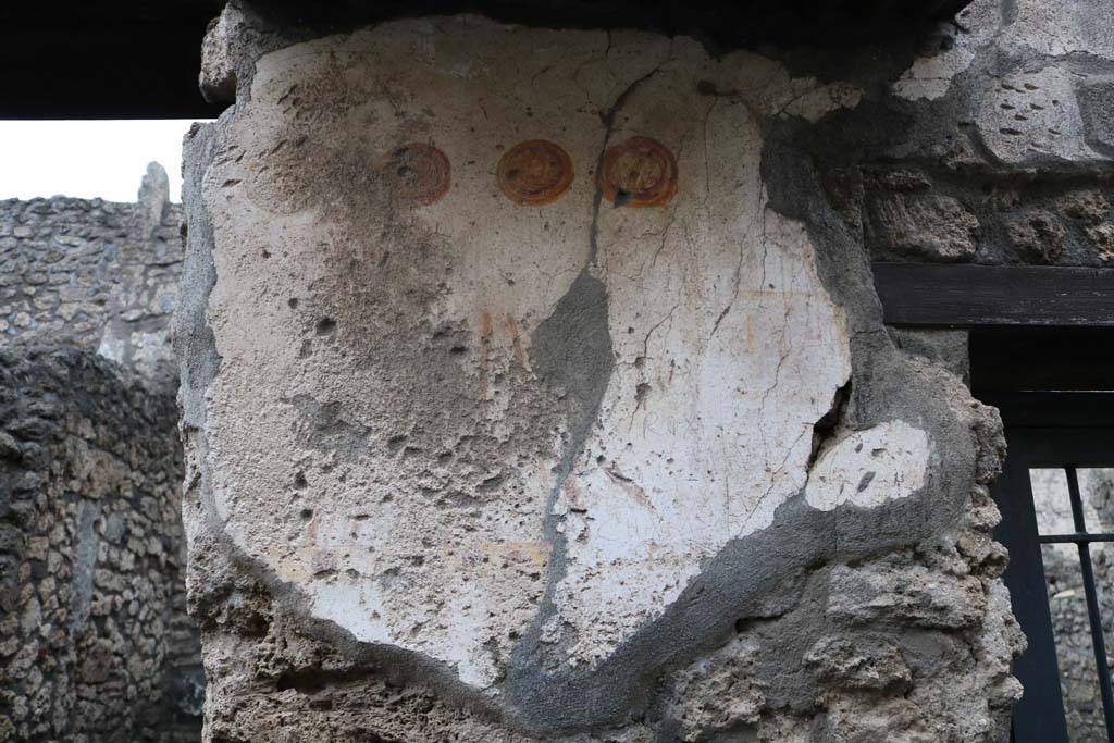 II.1.13 Pompeii. December 2018. Painted plaster on exterior wall, on north side (left) of entrance. Photo courtesy of Aude Durand.

