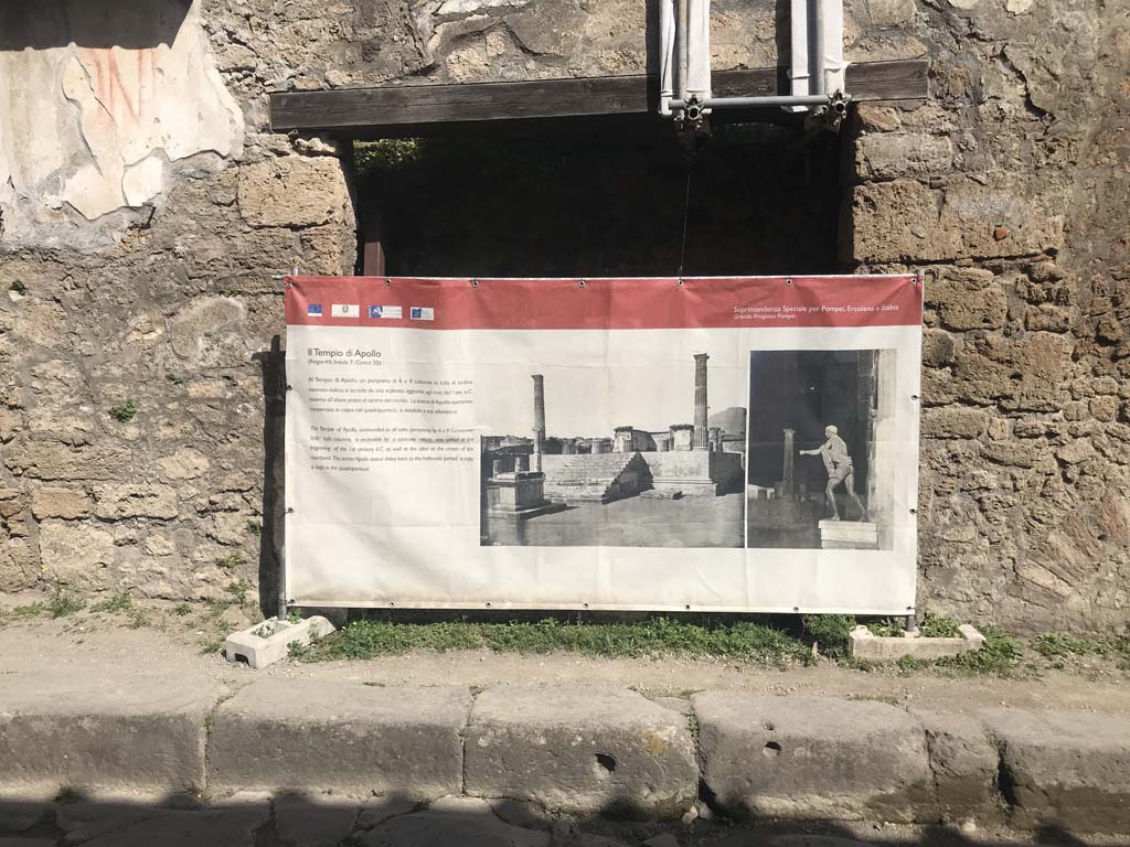 III.2.2 Pompeii. April 2019. Looking towards entrance to shop on north side of Via dell’Abbondanza.
The display board, advertising the Temple of Apollo, is a temporary screen.
The Temple of Apollo is to be found in Reg.VII.7.32, on the west side of the Forum.
Photo courtesy of Rick Bauer.
