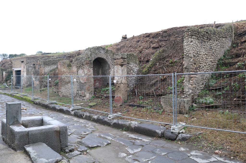 III.6.6 Pompeii, on right, next to unexcavated roadway, directly on right. December 2018. 
Looking west along insula III.6, on north side of Via dell’Abbondanza, looking towards III.6.1, on left. Photo courtesy of Aude Durand.

