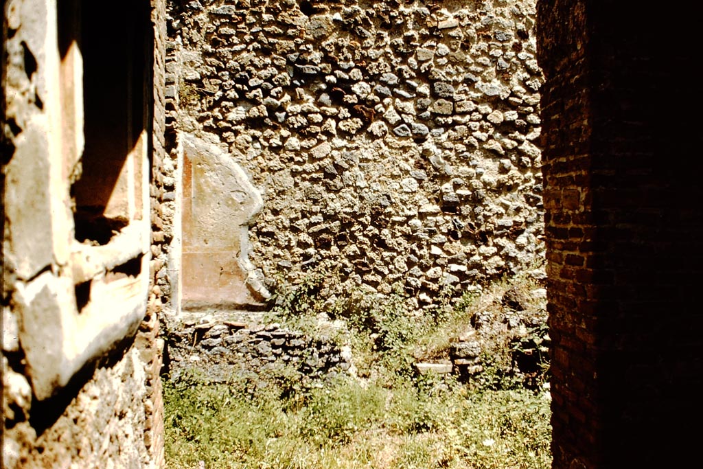 V.1.28 Pompeii. 1959. Looking east along fauces to atrium. Photo by Stanley A. Jashemski.
According to Wilhelmina, this house had no garden but in the north-east corner of the atrium in compensation, there was a garden painting.
The only description was from Overbeck-Mau who described a garden painting with plants and birds on a yellow background, above a high red dado. 
The painting has now faded. In 1972, Wilhelmina could only just make out three leaves.
Source: The Wilhelmina and Stanley A. Jashemski archive in the University of Maryland Library, Special Collections (See collection page) and made available under the Creative Commons Attribution-Non-Commercial License v.4. See Licence and use details.
J59f0436
See Jashemski, W. F., 1993. The Gardens of Pompeii, Volume II: Appendices. New York: Caratzas. (p.335)
