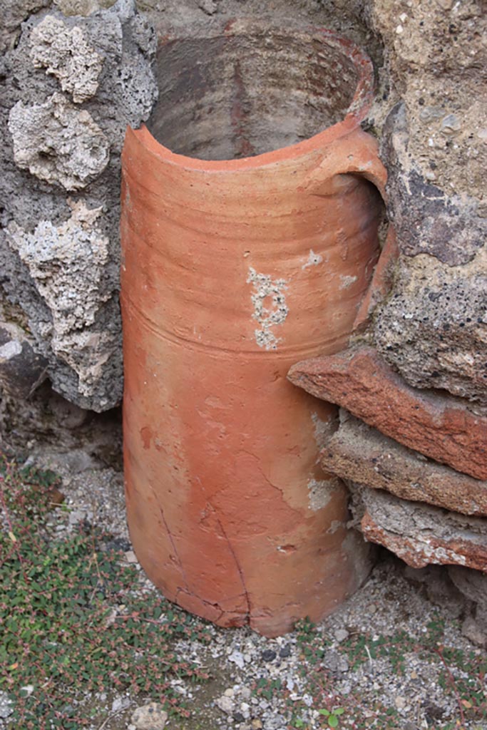 V.2.9 Pompeii. October 2022. 
Detail of downpipe set into east wall of rear room. Photo courtesy of Klaus Heese.
