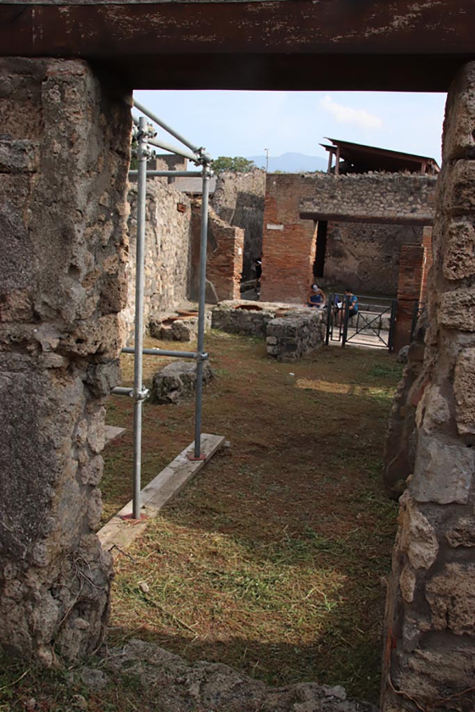 V.2.20 Pompeii. October 2022. 
Looking south through doorway into rear room of V.2.19. Photo courtesy of Klaus Heese.

