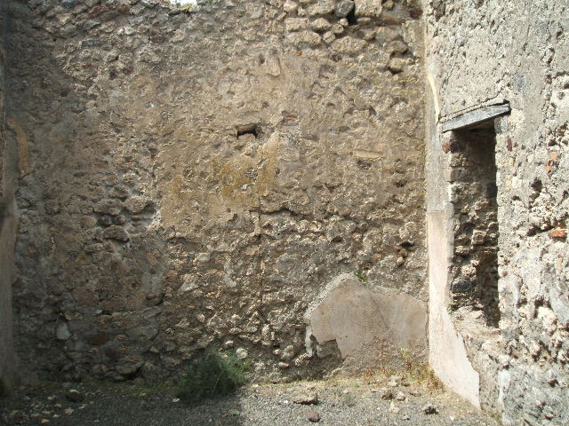 V.2.e Pompeii. May 2005. Room on north side of entrance doorway, with window to garden area. This was discovered with rough, coarse walls, and with dado and flooring both of brick plaster. According to Eschebach this room may have been an oecus or a triclinium.
