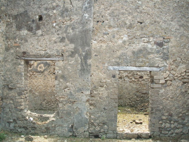 V.2.e Pompeii. May 2005. East wall of garden area, with window to triclinium, on left, and doorway to kitchen and latrine, on right.
