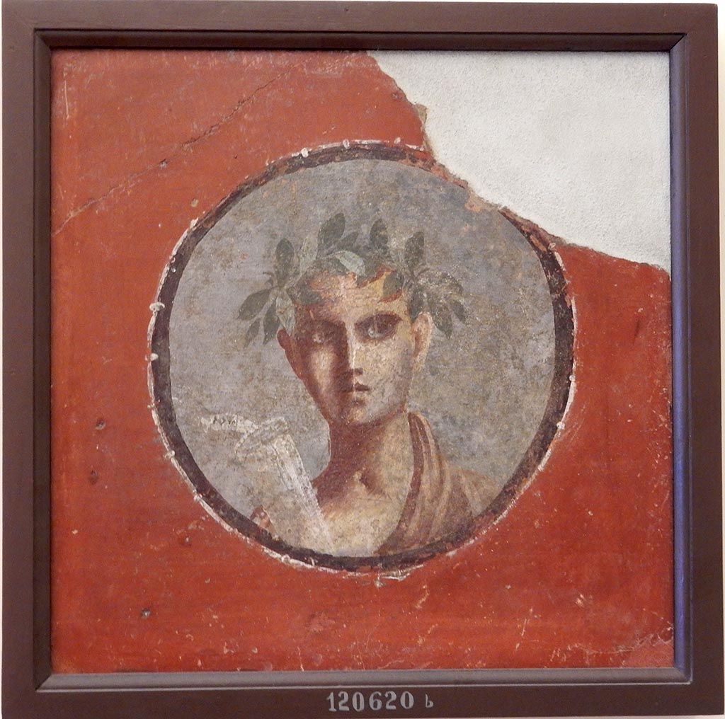 V.2.h Pompeii. 1892. Found in the tablinum, a portrait of male youth with crown.
The word PLATO was written on the scroll. [CIL IV 3445]. 
Now in Naples Archaeological Museum. Inventory number 120620b.
See 13 gen 1892 NSA 1892, 28 V, ii, H, f.
Our thanks to Raffaele Prisciandaro for his help in identifying this object.
See Richardson, L., 2000. A Catalog of Identifiable Figure Painters of Ancient Pompeii, Herculaneum. Baltimore: John Hopkins. (p.102)
