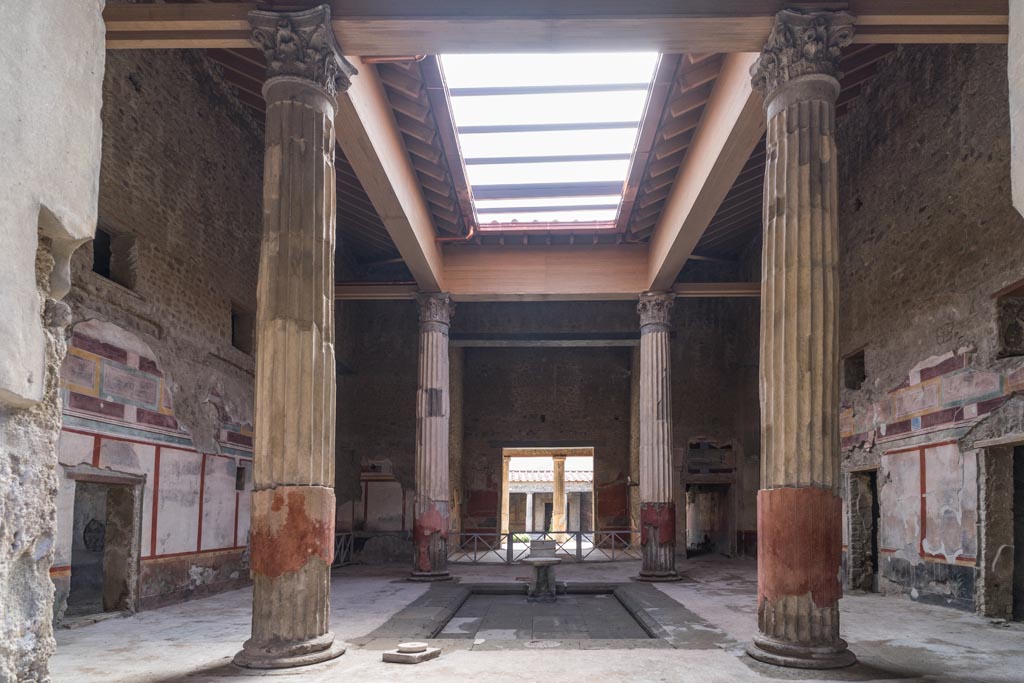 V.2.i Pompeii. March 2023. Room 1, atrium, south end of impluvium. 
Looking west towards travertine puteal, rectangular marble base and stone basin on a stand. Photo courtesy of Johannes Eber.
