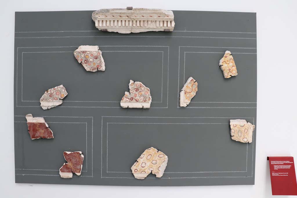 V.2.Pompeii. Casa di Orione. February 2021. 
Fragments of painted stucco decoration from entrance corridor/fauces, imitating the First Style marble slabs, on display in Antiquarium at VIII.1.4.
Photo courtesy of Fabien Bièvre-Perrin (CC BY-NC-SA).
